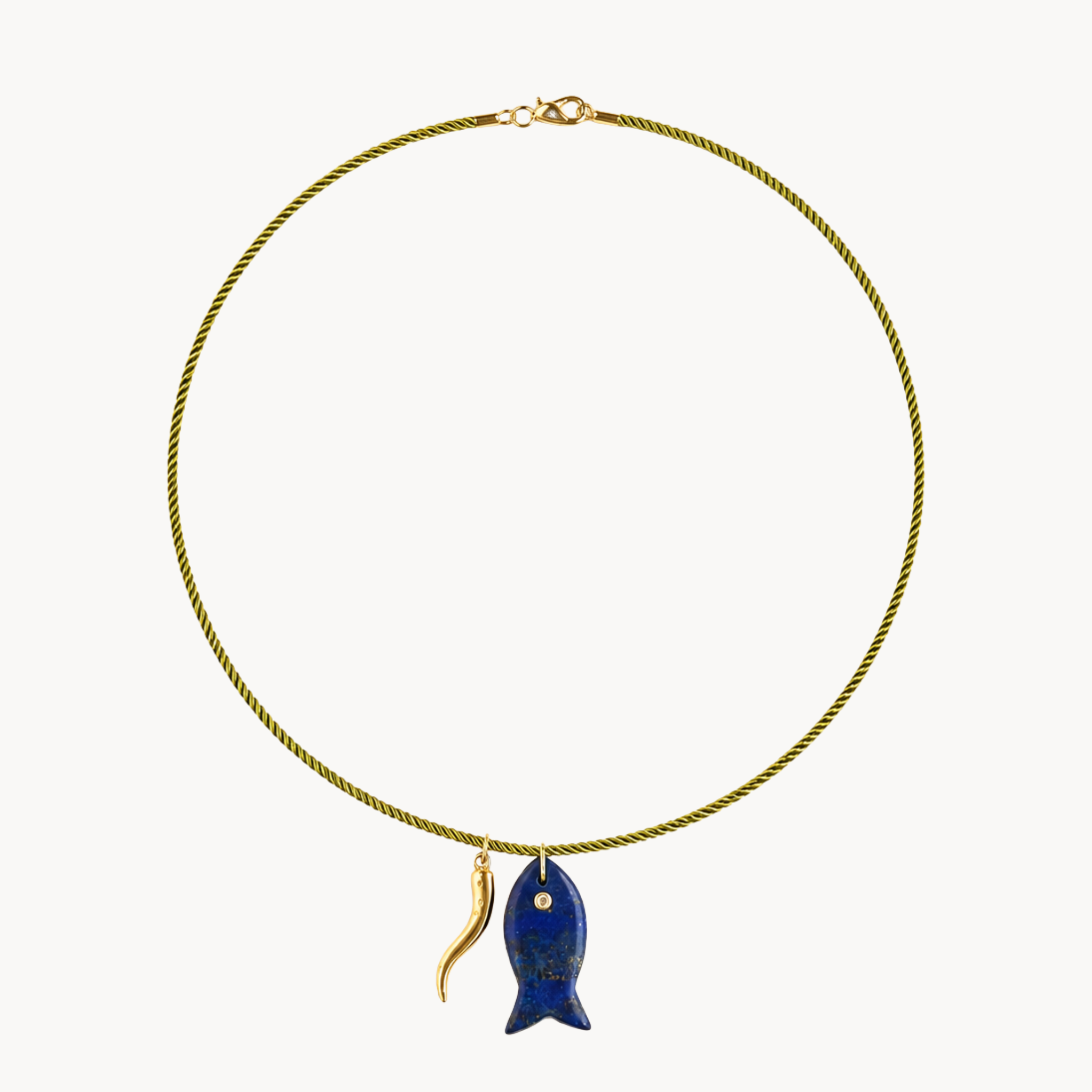 Olive cord necklace with blue carved fish pendant and sculptural gold charm on a clean background.