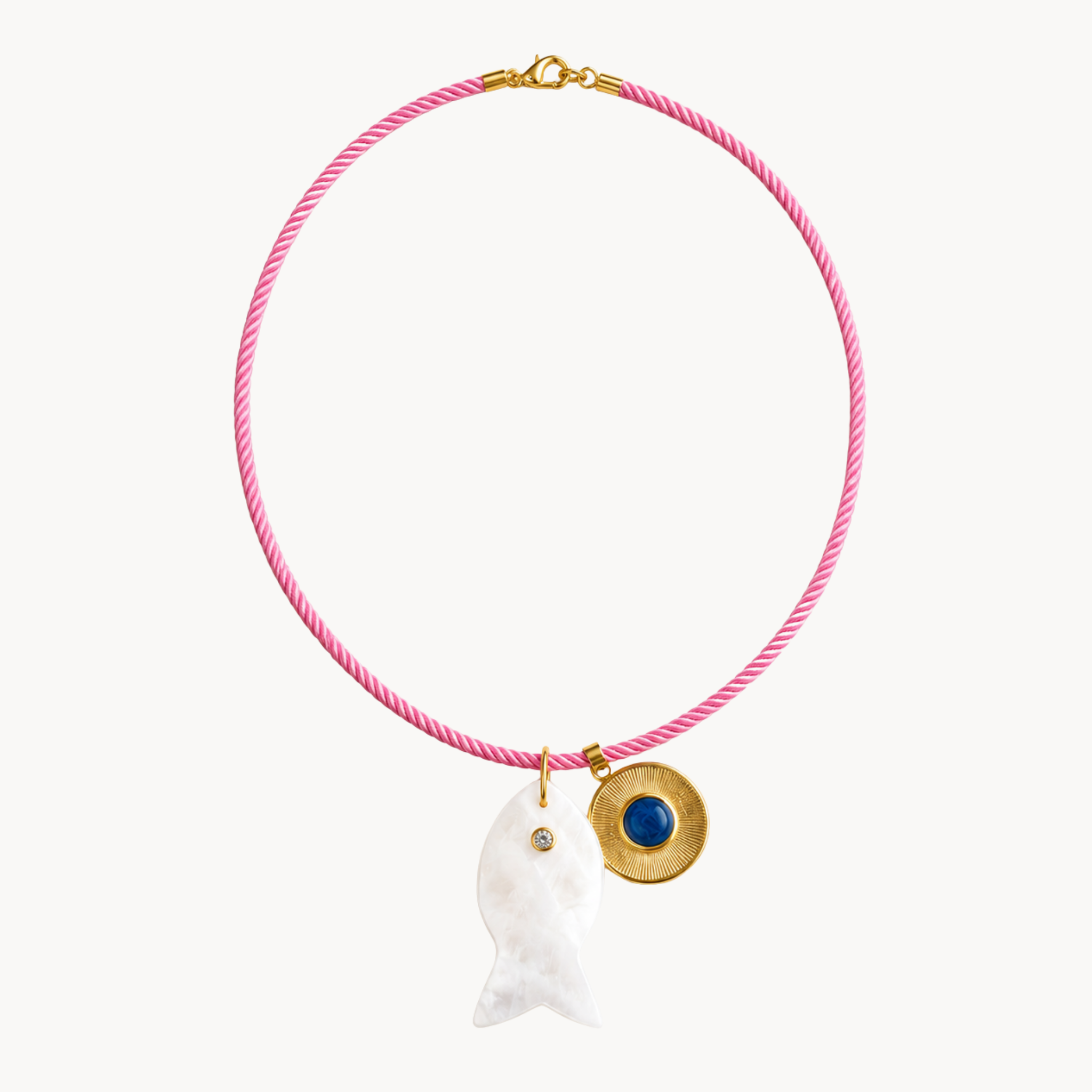 Pink cord necklace with mother-of-pearl fish pendant and gold medallion with blue stone charm.
